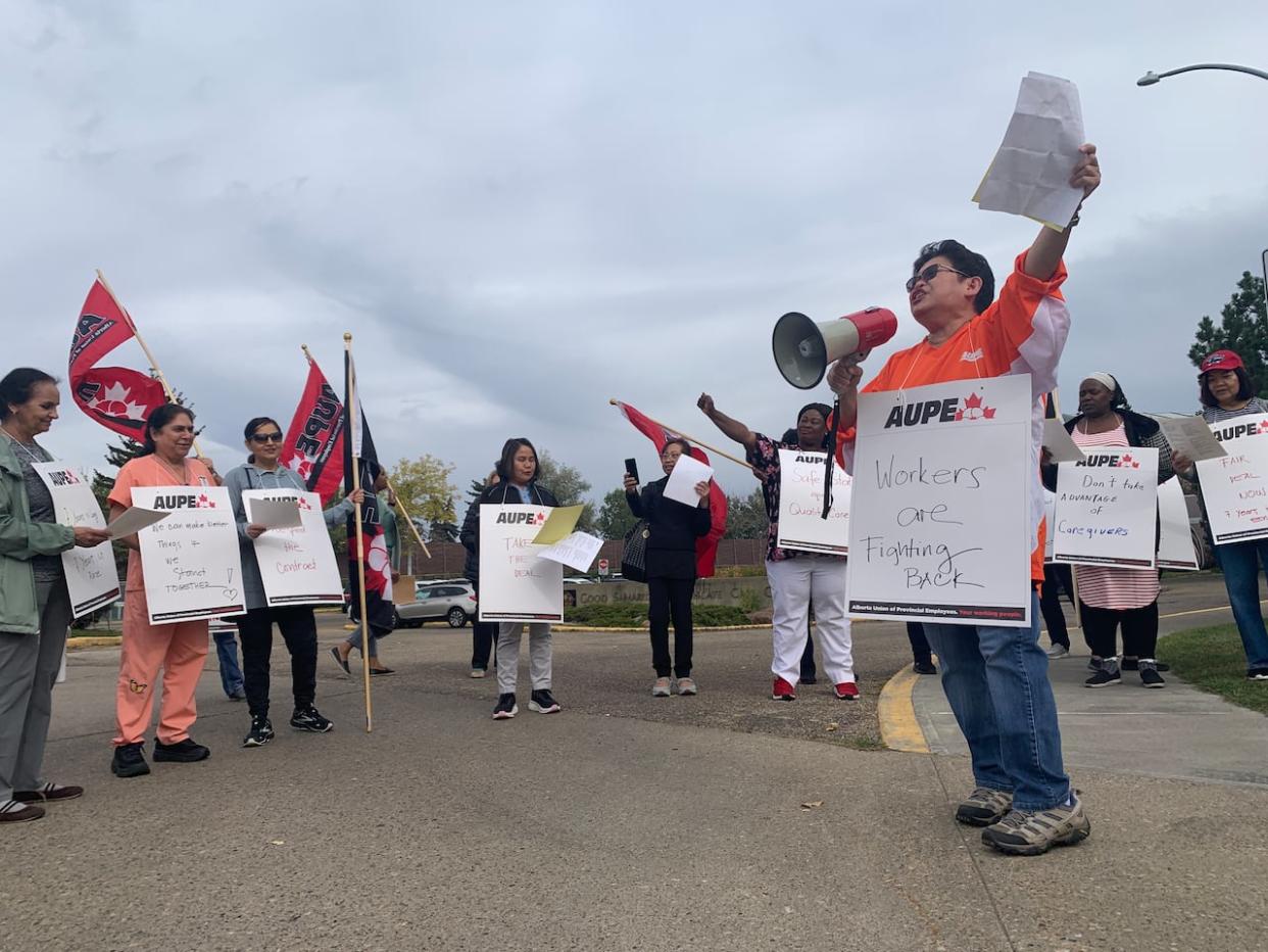 Faye Mosurafe, a licensed practical nurse and union chapter treasurer with the Alberta Union of Provincial Employees (AUPE), rallies with fellow members outside the Good Samaritan Southgate Care Centre in Edmonton on Sept. 26. (Madeleine Cummings/CBC - image credit)