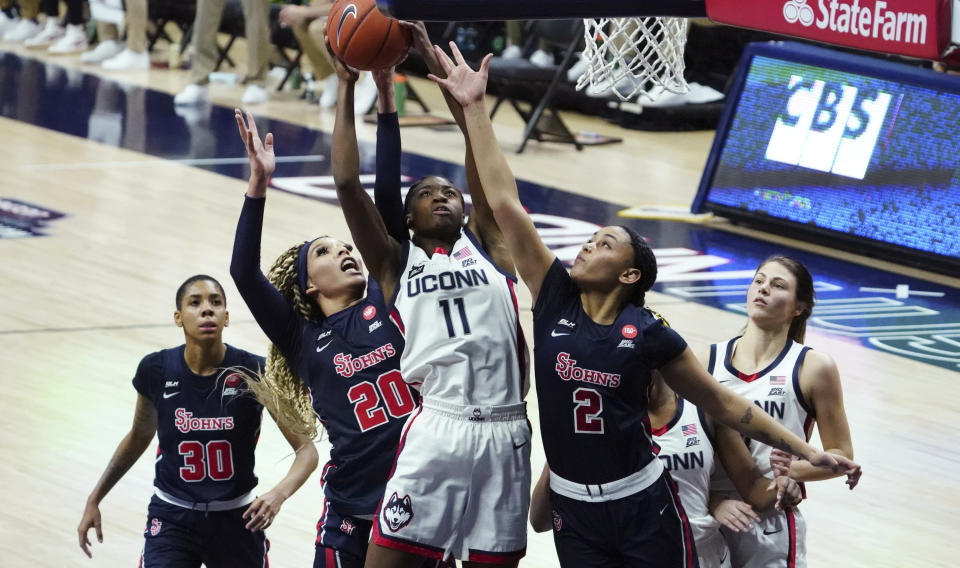 Connecticut forward Mir McLean (11) works the ball against St. John's forward Rayven Peeples (20) and guard Leilani Correa (2) during the second half of an NCAA college basketball game Wednesday, Feb. 3, 2021, in Storrs, Conn. (David Butler II/Pool Photo via AP)