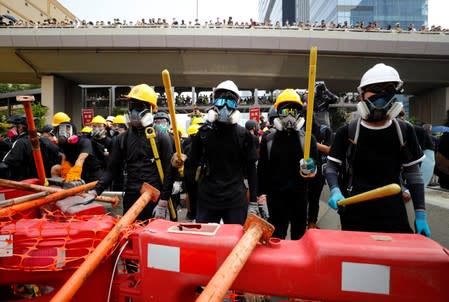 Demonstrators stand behind barricades during a protest in Hong Kong