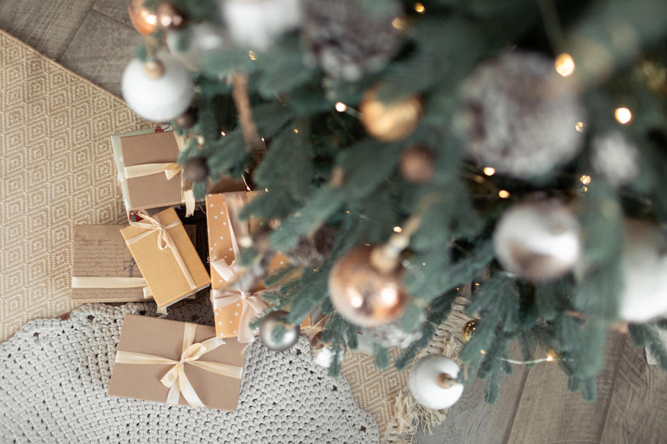 Pile of wrapped presents beneath a Christmas tree