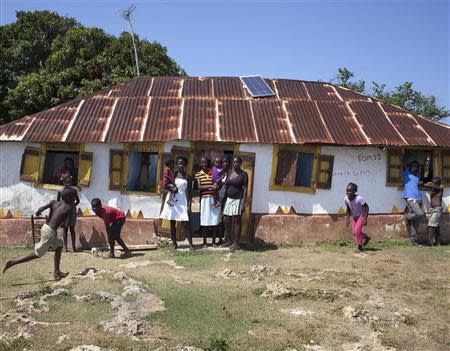 Artesia Suprice (C, yellow striped shirt) stands with her family outside their home which is one of dozens that will be expropriated by Haiti's government to make way for an international airport, on Ile-a-Vache island, off Haiti's south coast, March 25, 2014. REUTERS/stringer