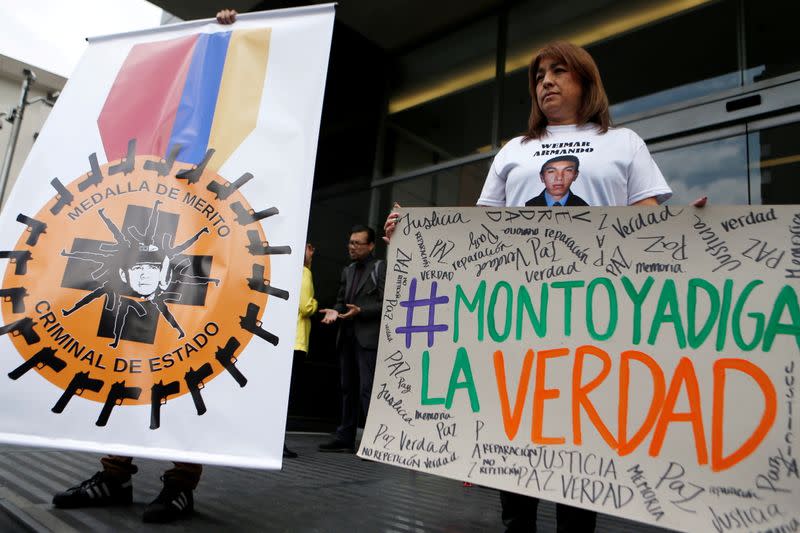 FILE PHOTO: A relative of a victim of "false positives" holds a sign during a protest against former Colombian commander Montoya in Bogota