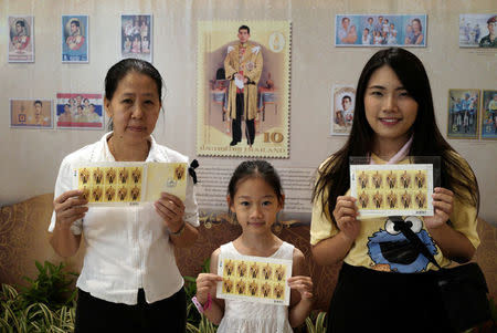 A family pose after buying mail stamps printed as part of the celebrations for the 65th birthday of Thai King Maha Vajiralongkorn in Bangkok, Thailand, July 28, 2017. REUTERS/Athit Perawongmetha