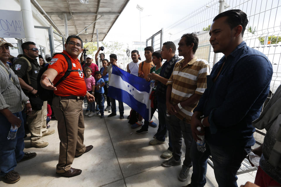 Un funcionario de inmigración mexicano recibe a un grupo de migrantes cuando cruzan la frontera hacia México desde Guatemala, cerca de Ciudad Hidalgo, estado de Chiapas, México, el jueves 17 de enero de 2019. (AP Foto/Marco Ugarte)