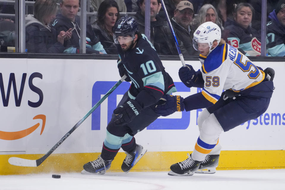 Seattle Kraken center Matty Beniers (10) moves the puck against St. Louis Blues center Nikita Alexandrov (59) during the first period of an NHL hockey game Friday, Jan. 26, 2024, in Seattle. (AP Photo/Lindsey Wasson)