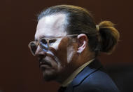 Actor Johnny Depp gets up during a break in the courtroom at the Fairfax County Circuit Courthouse in Fairfax, Va., Wednesday, May 18, 2022. Actor Johnny Depp sued his ex-wife Amber Heard for libel in Fairfax County Circuit Court after she wrote an op-ed piece in The Washington Post in 2018 referring to herself as a "public figure representing domestic abuse." (Kevin Lamarque/Pool Photo via AP)