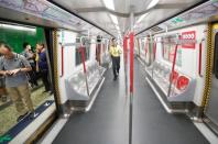 A Mass Transit Railway (MTR) service personnel asks passengers to leave a train as protesters disrupt subway services at Fortress Hill station in Hong Kong