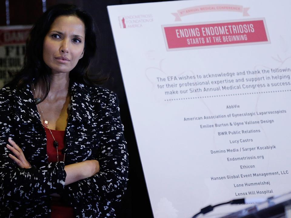 Padma Lakshmi next to a sign that reads "ending endometriosis"