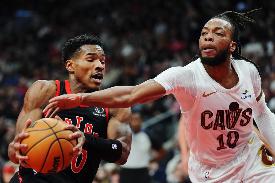 Toronto Raptors guard Ochai Agbaji (30) protects the ball from Cleveland Cavaliers guard Darius Garland (10) during the first half of an NBA basketball game, Saturday, Feb. 10, 2024 in Toronto. (Frank Gunn/The Canadian Press via AP)