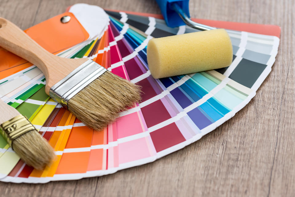 Paint brushes on colour swatch, wooden table background