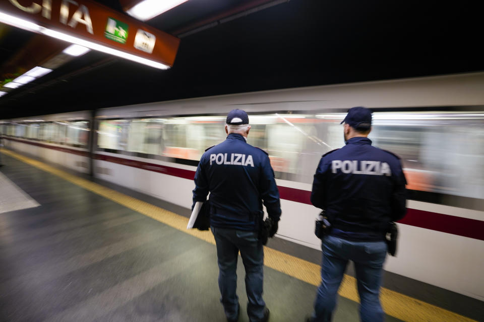 Policemen wait on a platform to check the green health pass of public transportation passengers in Rome, Monday, Dec. 6, 2021, on the first day a super green health pass went into effect. Italian police can check whether diners in restaurants or bars have a "super" green health pass certifying that they are either vaccinated or have recently recovered from the virus. (AP Photo/Andrew Medichini)