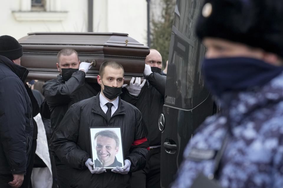 FILE - Workers carry the coffin and a portrait of Russian opposition leader Alexei Navalny at his funeral in Moscow, Friday, March 1, 2024. Navalny died in an Arctic prison colony. (AP Photo/File)