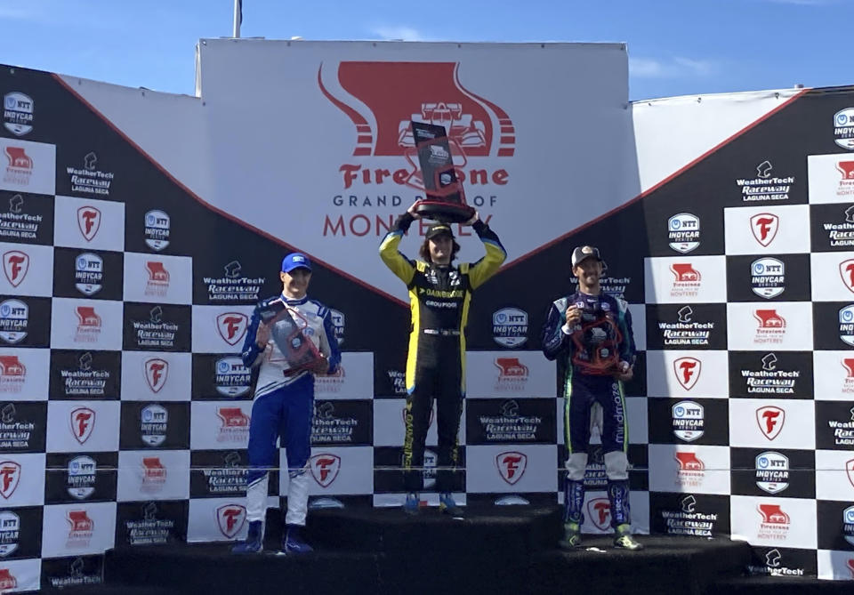 Colton Herta, center, celebrates his IndyCar victory at Laguna Seca with runner-up Alex Palou, left, and Romain Grosjean, Sunday, Sept. 19, 2021, in Monterey, Calif. Palou stretched his lead in the championship standings to 35 points headed into next week's season finale. (AP Photo/Jenna Fryer)