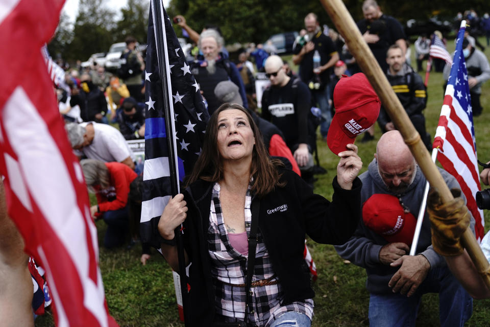 Members of the Proud Boys and other right-wing demonstrators kneel in prayer at a rally on Saturday, Sept. 26, 2020, in Portland, Ore. (AP Photo/John Locher)