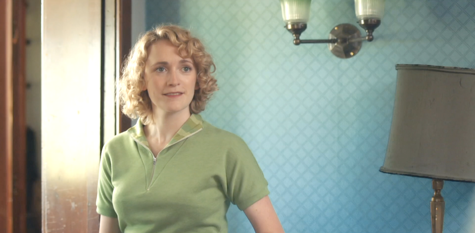 charlotte ritchie as bonnie in grantchester, tightly curled blonde hair and wearing a green tshirt, young woman slightly smiling