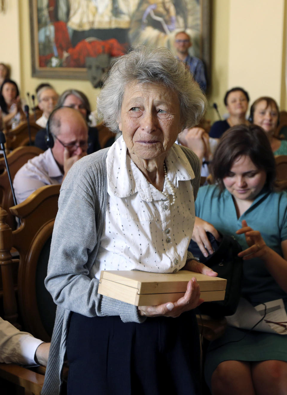 Yanina Hescheles, Polish writer and a Nazi concentration camp survivor, holds a glass copy of an old metal synagogue key at a ceremony commemorating the 75th anniversary of the annihilation of the city's Jewish population by Nazi Germany in Lviv, Ukraine, Sunday, Sept. 2, 2018. The Ukrainian city of Lviv, once a major center of Jewish life in Eastern Europe, is commemorating the 75th anniversary of the annihilation of the city's Jewish population by Nazi Germany and honoring those working today to preserve that vanished world. The commemoration comes amid a larger attempt in Ukraine to preserve the memories of the prewar Jewish community. (AP Photo/Yevheniy Kravs)