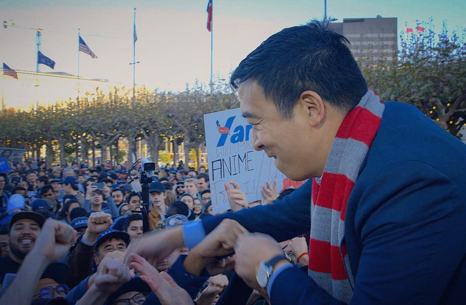 Andrew Yang fist-bumps supporters at a recent rally in San Francisco. The presidential hopeful says his focus on economic issues cuts across ethnic divisions.