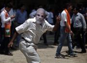 A supporter of India's Bharatiya Janata Party (BJP), wearing a mask of Hindu nationalist Narendra Modi, the prime ministerial candidate for BJP, celebrates after learning the initial poll results at the party headquarters in New Delhi May 16, 2014. REUTERS/Adnan Abidi