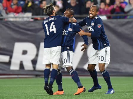 May 12, 2018; Foxborough, MA, USA; New England Revolution forward Diego Fagundez (14) and forward Teal Bunbury (10) celebrate after a goal by forward Cristian Penilla (middle) with during the first half against Toronto FC at Gillette Stadium. Mandatory Credit: Bob DeChiara-USA TODAY Sports