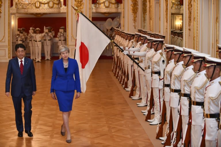 British Prime Minister Theresa May reviews the guard of honour with Japan's Prime Minister Shinzo Abe during a welcoming ceremony at the state guest house in Tokyo in August