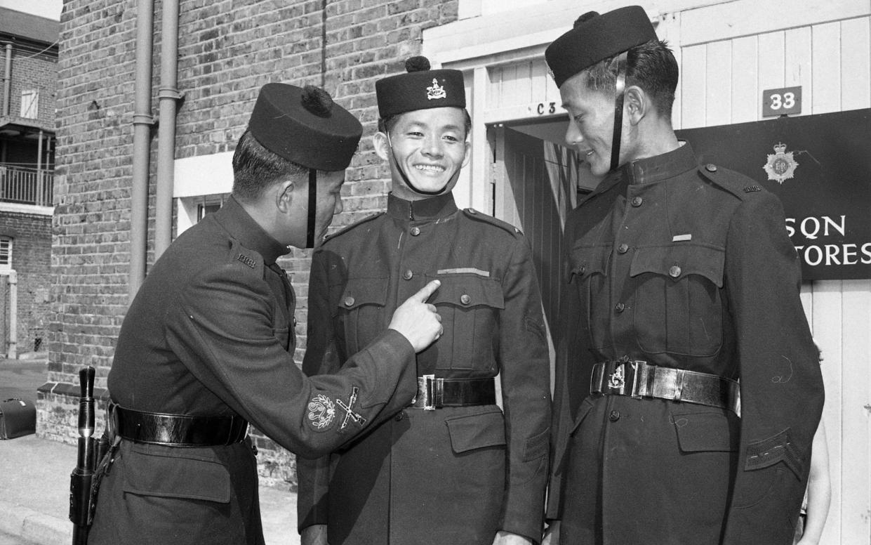 Comrades from Princess Mary’s Own Gurkha Rifles inspect Ram Bahadur Limbu's Victoria Cross ribbon at Regent's Park barracks - Bill Russell