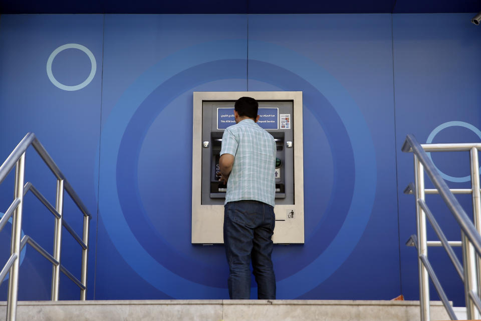 A man uses ATM outside a closed bank, in Beirut, Lebanon, Tuesday, Nov. 12, 2019. Lebanon's banking association says banks will stay closed due to a strike by employees, as country's financial crisis worsens. (AP Photo/Bilal Hussein)