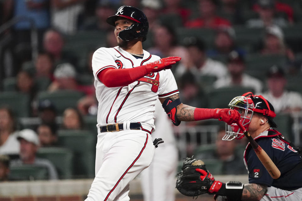 Atlanta Braves' Orlando Arcia (11) follows through on a two-run walkout home run as Boston Red Sox catcher Christian Vazquez (7) looks on in the ninth inning of a baseball game Wednesday, May 11, 2022, in Atlanta. (AP Photo/John Bazemore)