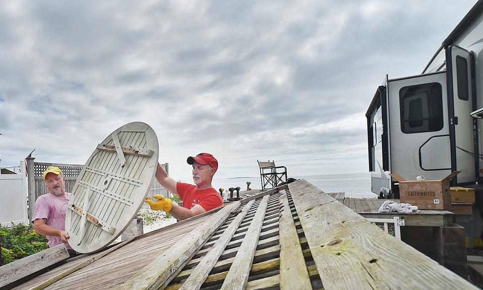 Dennis Pelletier helps his brother David remove items from his lot near Westport Town Beach on Tuesday, Sept. 12.