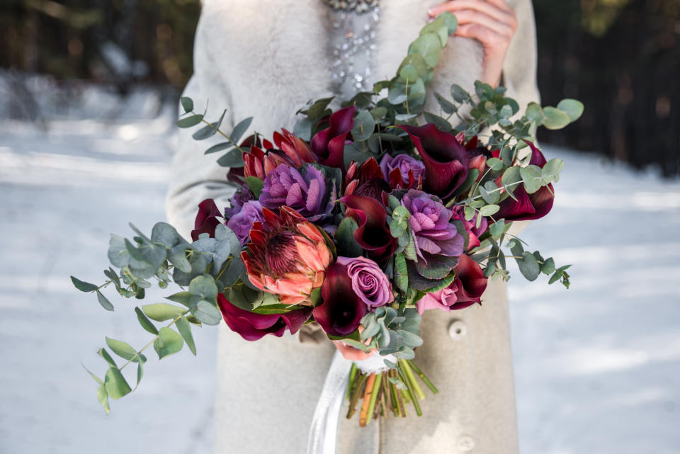 Wedding bouquet in hands of the bride. Winter time, snowy fores