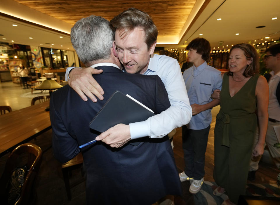Denver mayoral candidate Mike Johnston, right, is congratulated by hotelier Walter Isenberg before Johnston enters an election eve watch party in a hotel late Tuesday, April 4, 2023, in lower downtown Denver. Johnston and Kelly Brough were the top vote-getters in the race, which featured 16 candidates. (AP Photo/David Zalubowski)