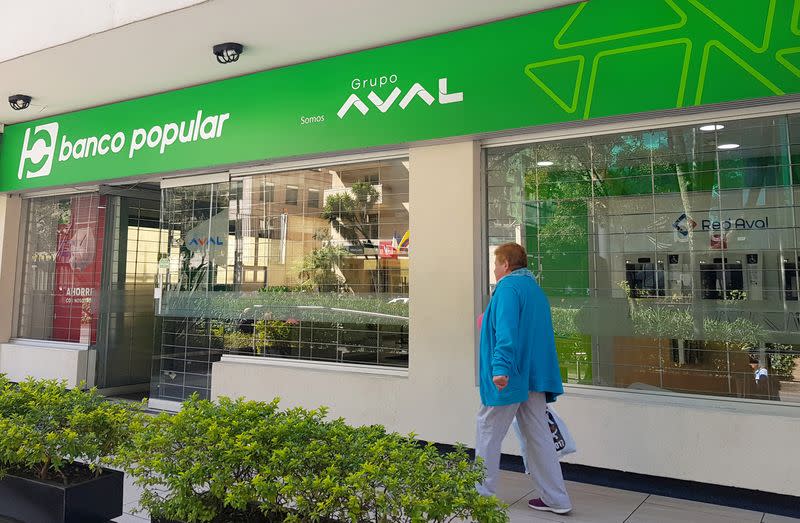 Foto de archivo. Una mujer camina frente a una oficina del Banco Popular, parte del Grupo Aval, en Bogotá