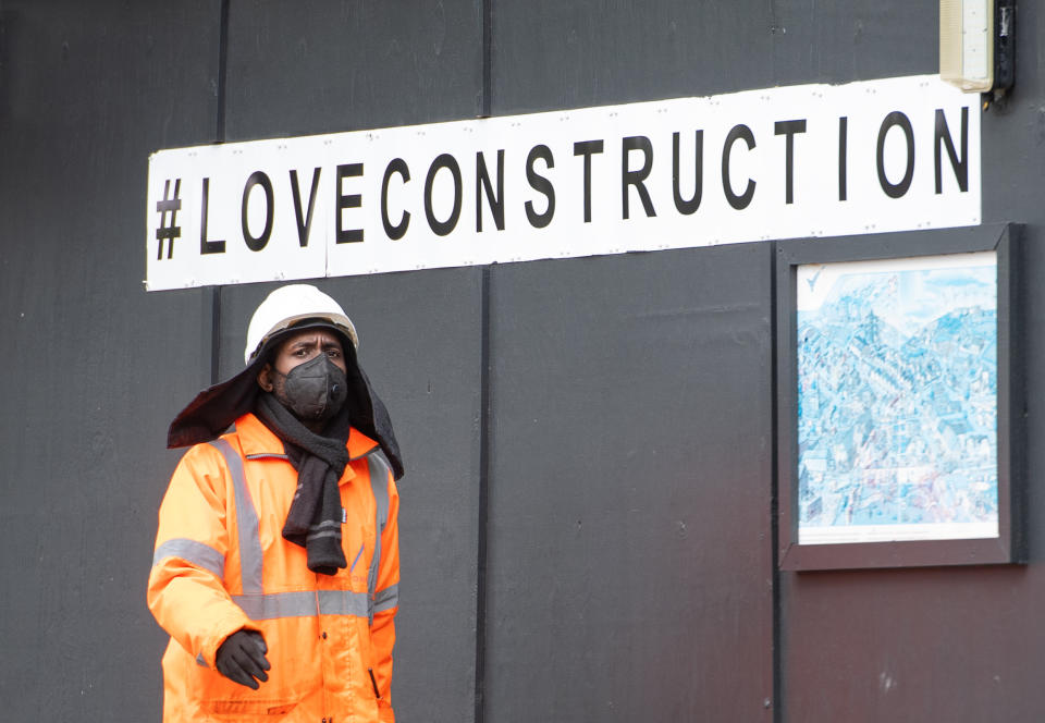 A construction worker wearing a protective face mask at a building site in central London