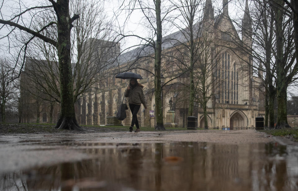 A person walks through the grounds of Winchester Cathedral.