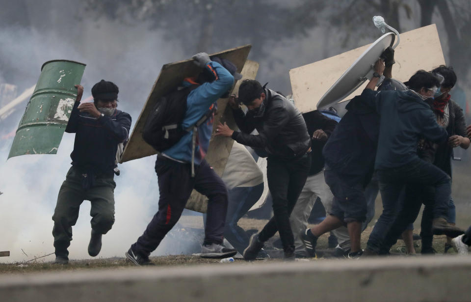 Anti-government protesters clash with police near the National Assembly during a military curfew in Quito, Ecuador, Sunday, Oct. 13, 2019. Deadly protests against a plan to remove fuel subsidies as part of an International Monetary Fund austerity package have gone on for more than a week. (AP Photo/Dolores Ochoa)