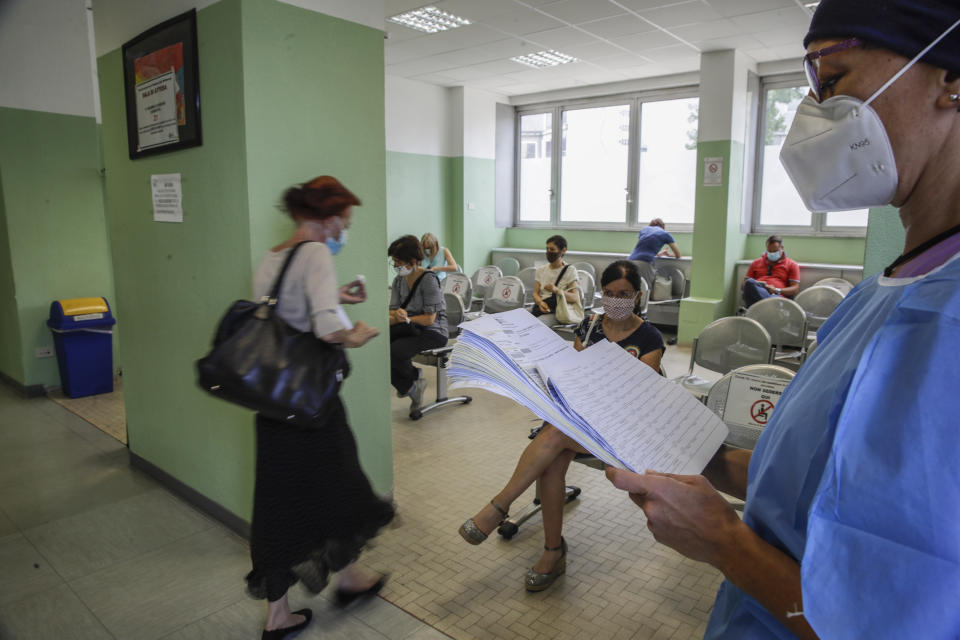 A medical worker calls teachers and school staff for a blood COVID-19 test at the San Carlo Hospital in Milan, Italy, Wednesday, Aug. 26, 2020. Despite a spike in coronavirus infections, authorities in Europe are determined to send children back to school. Italy, Europe’s first virus hot spot, is hiring 40,000 more temporary teachers and ordering extra desks, but some won’t be ready until October. (AP Photo/Luca Bruno)