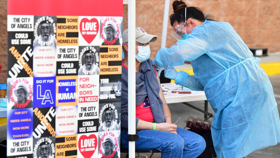 Image: Registered nurse Rhonda Ahn administers the Moderna Covid-19 vaccine to eligible people identified by homeless service agencies from the parking lot of the L.A. Mission (Frederic J. Brown / AFP - Getty Images)