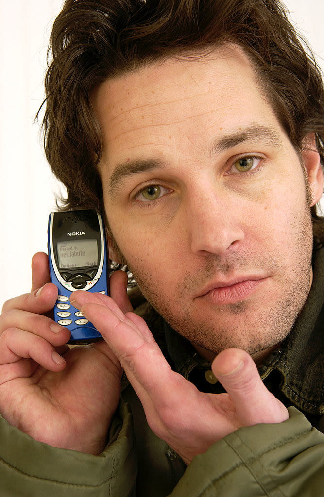 In a close-up, he's holding up a very small Nokia cellphone