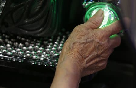 A woman plays pachinko at Dynam's pachinko parlour in Fuefuki, west of Tokyo June 19, 2014. REUTERS/Issei Kato