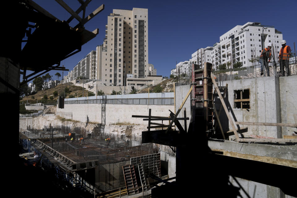 Palestinian laborers work at a construction site in a new housing project in Har Homa, an Israeli settlement in east Jerusalem that Israel considers a neighborhood of its capital, Wednesday, July 6, 2022. The White House says Palestinians are entitled to the same measure of "freedom, security and prosperity" enjoyed by Israelis, but when President Joe Biden visits the region this month he will have few accomplishments to point to. (AP Photo/Mahmoud Illean)