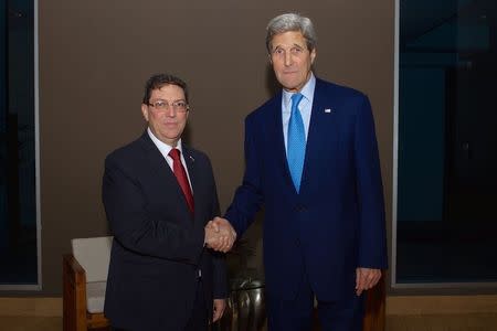 U.S. Secretary of State John Kerry (R) shakes hands with Cuban Foreign Minister Bruno Rodríguez in Panama City, Panama April 9, 2015 in this handout photo, as they hold a bilateral meeting - the first between officials at their level since 1958 - on the sidelines of the Summit of the Americas. REUTERS/U.S. State Department/Handout via Reuters