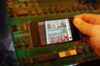 LONDON, ENGLAND - OCTOBER 09: A modern iPhone takes a photograph of an Apple-1 Personal Computer at Christie's on October 9, 2012 in London, England. Introduced in July 1976 the Apple-1 was sold without a casing, power supply, keyboard or monitor and buyers would have to supply their own. This rare personal computer has come from the estate of Joe Copson, a former Apple employee. The Apple-1 machine was designed and each model hand-built by Steve Wozniak. His friend Steve Jobs suggested a number of improvements, and handled it's sale and marketing. When offered at auction in Christie’s sale of Travel, Science and Natural History on October 9, 2012 it is expected to fetch between £50,000 and £80,000. (Photo by Peter Macdiarmid/Getty Images)