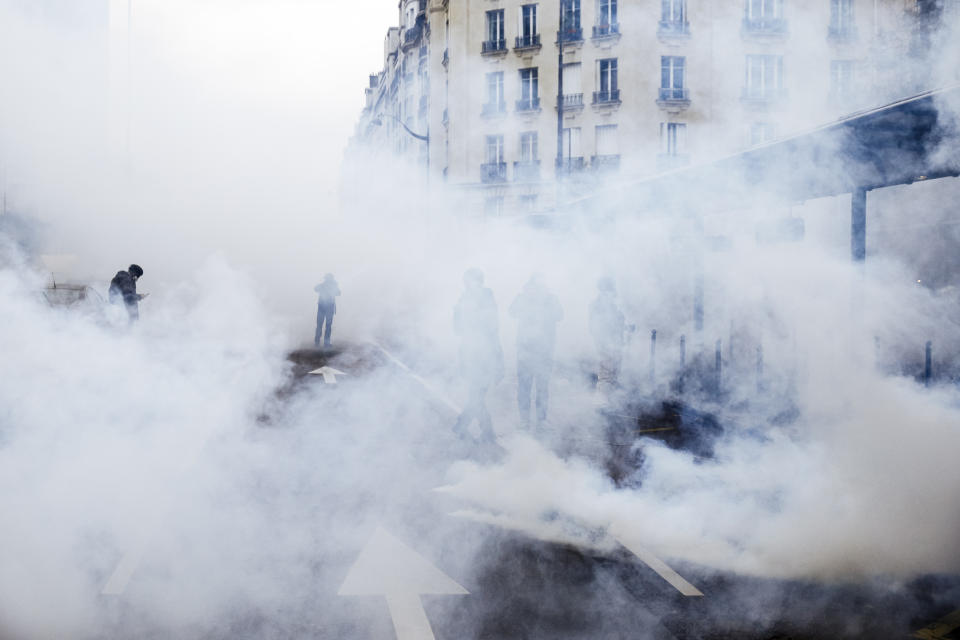 Tear gas envelopes protesters during a yellow vest demonstration marking the first anniversary in Paris, Saturday, Nov. 16, 2019. Paris police fired tear gas to push back yellow vest protesters trying to revive their movement on the first anniversary of the sometimes violent uprising against President Emmanuel Macron and government economic policies(AP Photo/Kamil Zihnioglu)