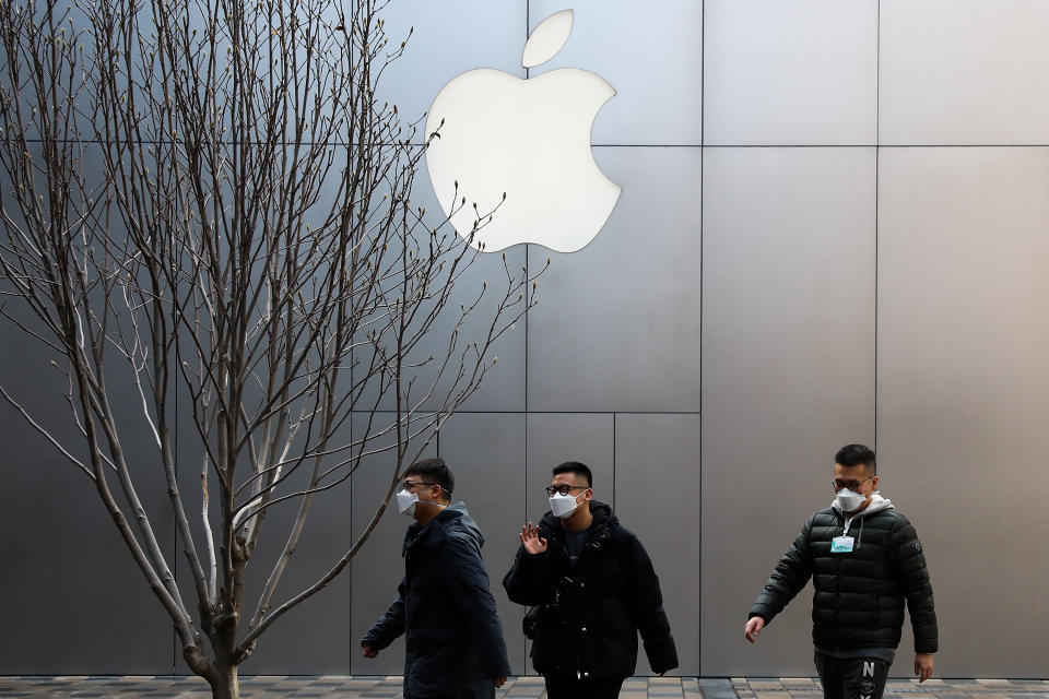 People wearing face masks walk past an Apple store in Beijing on February 17, 2020 in Beijing, China