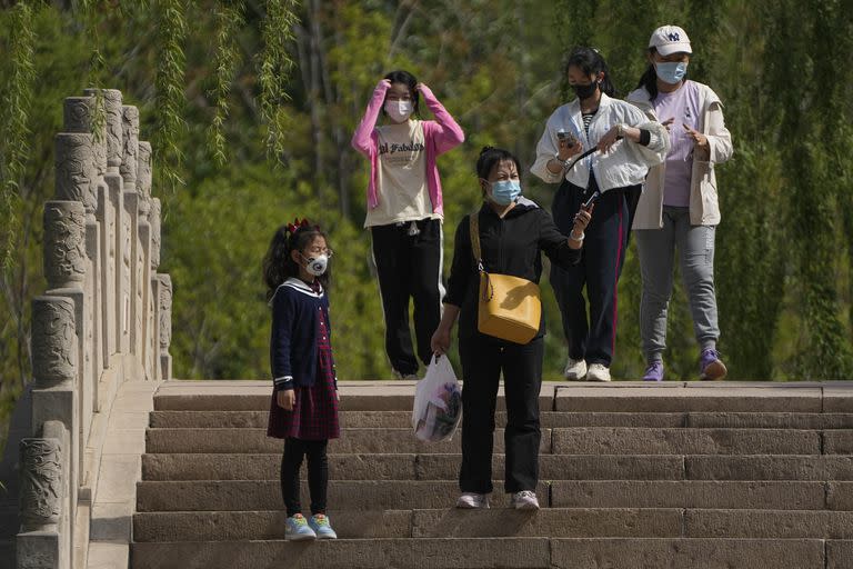 Residentes con mascarillas recorren el parque Longtan de Pekín, el domingo 16 de abril de 2023. 