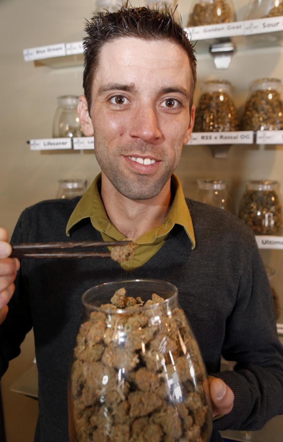 This Thursday, April 11, 2013, photo shows Matt Brown, co-owner of Denver'S new "My 420 Tours, shows a sampling of marijuana at a dispensary in Denver. "My 420 Tours," gives traveling pot users everything but the drug. Brown has sold 160 tour packages to visiting pot smokers for the April 20 weekend. Prices start at $499, not including hotel or air. Instead, the service plans to pick up marijuana tourists at the airport in limousines, escort them to Cannabis Cup and other Denver-area marijuana celebrations and take them to a cannabis-friendly hotel (a national chain that has given permission for Denver patrons to smoke marijuana on outdoor patios but doesn't want its name advertised). (AP Photo/Ed Andrieski)