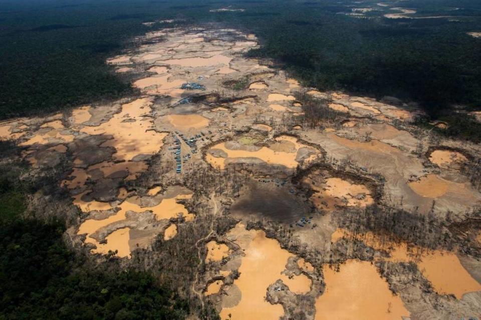 Illegal mining in Perú’s Madre de Dios region has turned rain forest into a moonscape of environmental destruction. This 2014 photo shows a deforested area dotted with blue tarps, marking the area where miners reside, and craters filled with water, mud and chemicals.