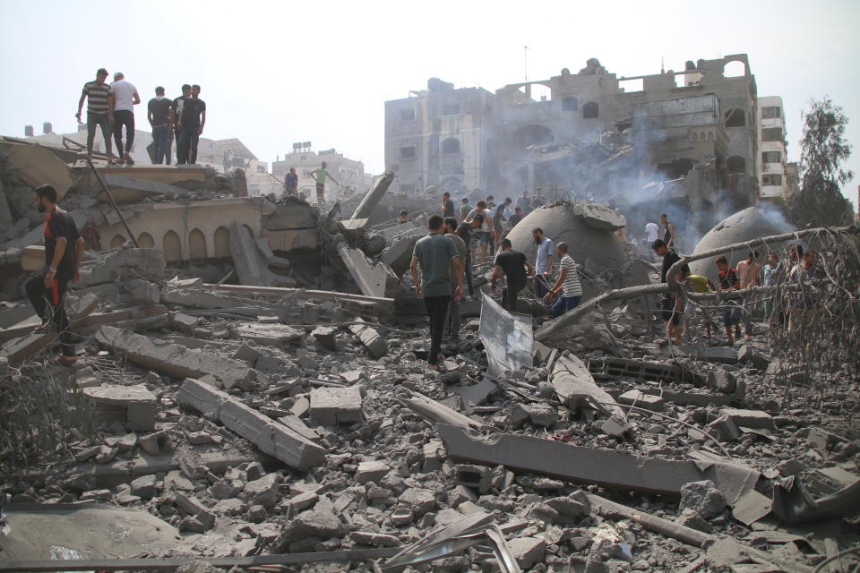 Palestinians inspect the damage to the Al-Sussi Mosque and their homes following Israeli air strikes