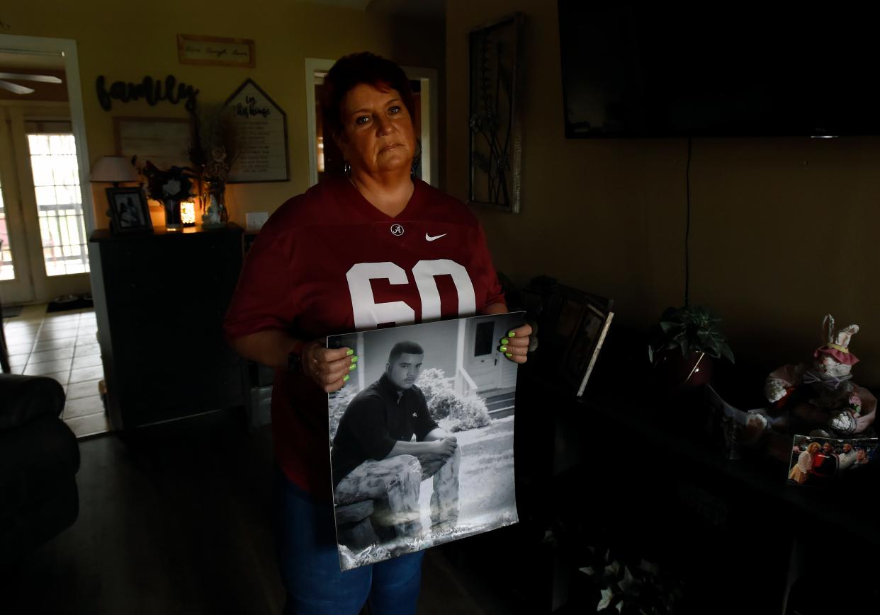 Tammy Barrett holds a high school photo of her son, Dallas, on Tuesday, March 29, 2022, in Smyrna, Tenn. Dallas Barrett died when he was 22 years old after a fight with security at Dierks Bentley’s Whiskey Row bar in downtown Nashville.
