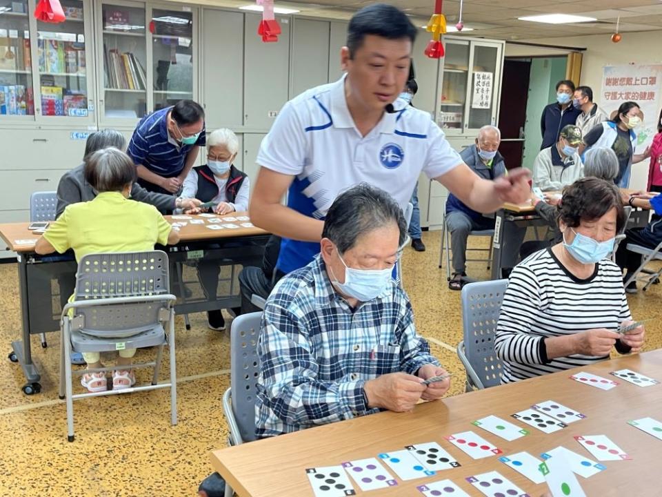 《圖說》康寧大學推廣教育中心鄭智宏老師(站立者)用心引導八德榮家住民長輩參與桌遊 練習手眼。〈八德榮家提供〉