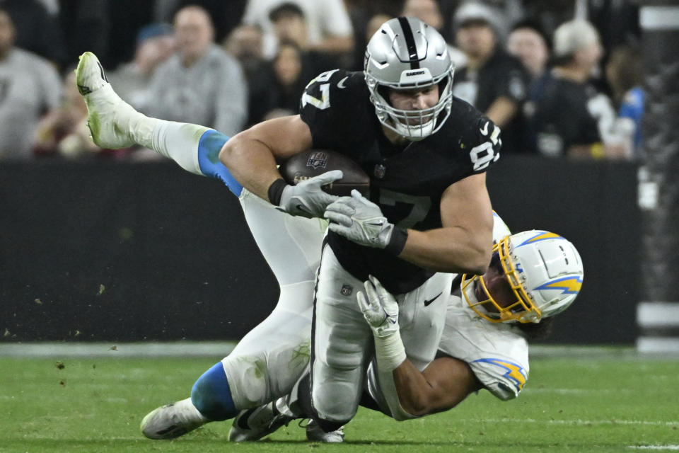Los Angeles Chargers linebacker Eric Kendricks (6) tackles Las Vegas Raiders tight end Michael Mayer (87) during the second half of an NFL football game, Thursday, Dec. 14, 2023, in Las Vegas. (AP Photo/David Becker)